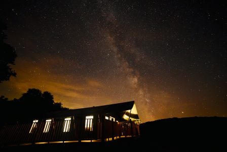 A night time image of the milky way and night sky above a safar ient with the last of the light in the sky