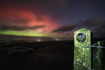 The sky is a mix of green, red and blue as the northern lights are seen across the sky, at Llanllwni dark sky discovery sight